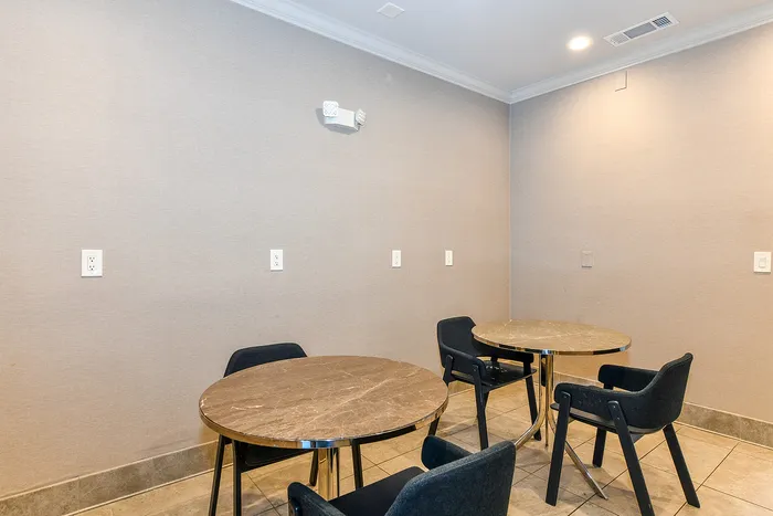 Cozy meeting nook with elegant round tables and modern chairs, perfect for small gatherings or quiet work sessions.