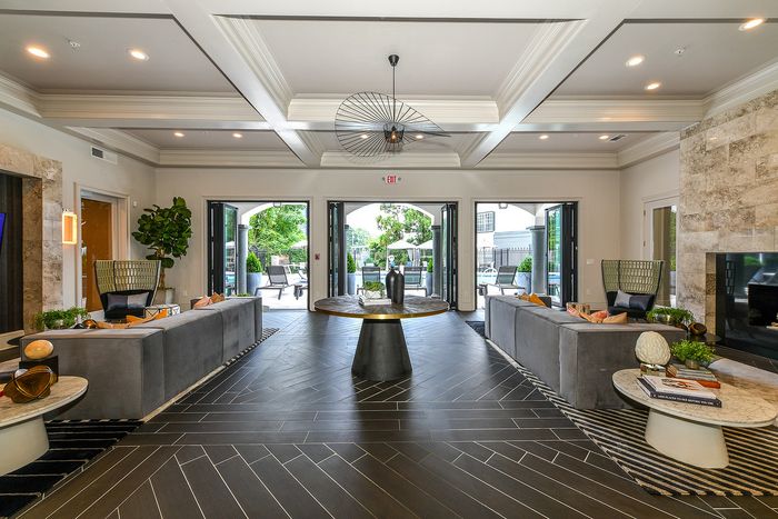 Luxurious and spacious living area with elegant decor, stunning floor-to-ceiling windows, and cozy seating, offering a seamless indoor-outdoor flow.
