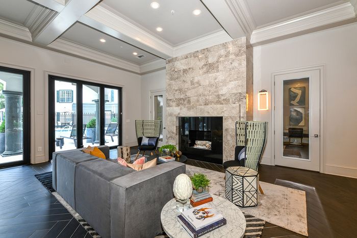 Elegant living room with a modern stone fireplace, stylish seating, and sleek decor, offering a luxurious and comfortable ambiance.