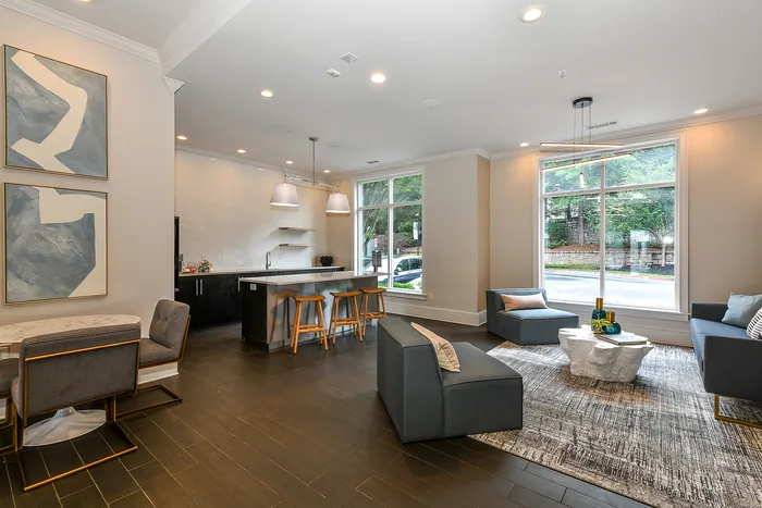 Chic open-concept living area with modern kitchen, elegant seating, and abundant natural light from large windows.