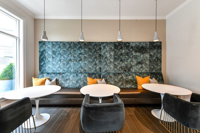Chic and modern lounge area with plush seating, stylish pendant lighting, and a textured accent wall, perfect for social gatherings.