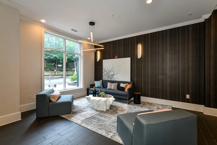 Elegant living room with modern lighting fixtures, large window views, and chic seating, creating a stylish and inviting atmosphere.
