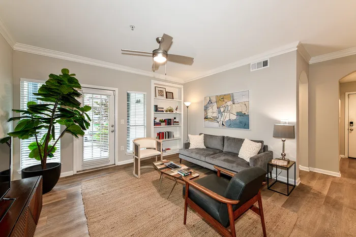 Charming living room with modern decor and natural light, featuring a plush sofa, cozy seating, and vibrant artwork.