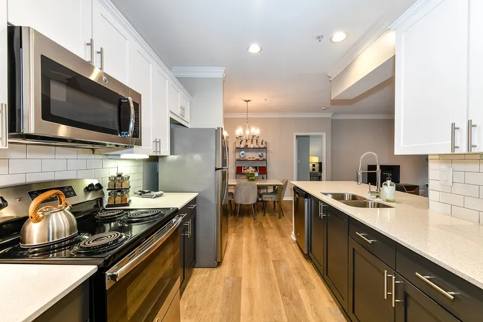 Modern kitchen with sleek stainless steel appliances, elegant white cabinetry, and a chic dining area perfect for entertaining.