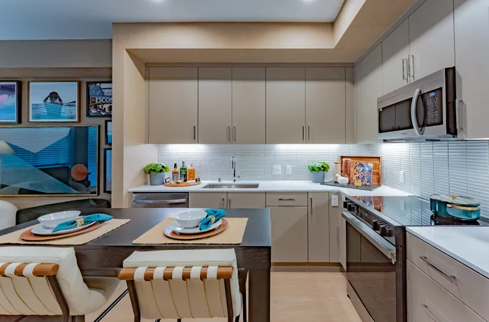 Elegant modern kitchen with sleek cabinetry, stainless steel appliances, and stylish dining setup.