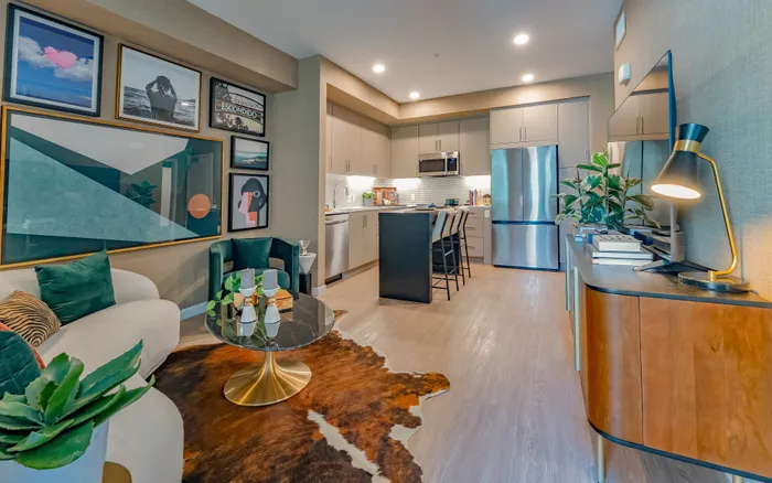 Chic open-concept living room with modern kitchen, stylish decor, and elegant artwork creating a cozy ambiance.