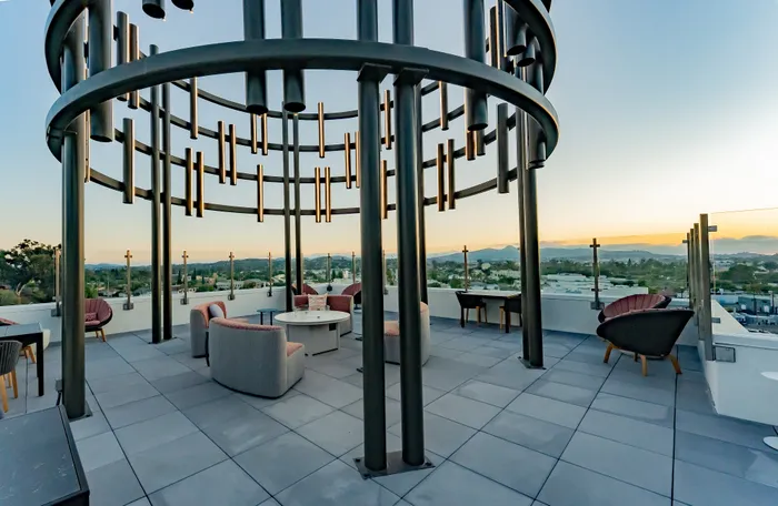 Luxurious rooftop terrace with chic seating and panoramic mountain views at sunset.