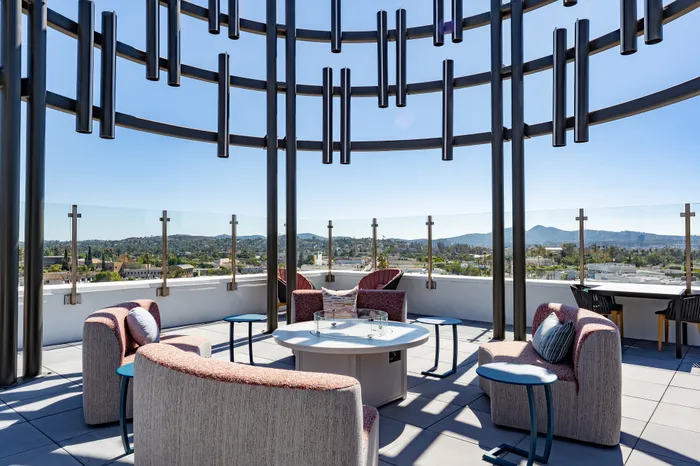 Chic rooftop terrace with modern seating and panoramic mountain views, perfect for relaxation and social gatherings.