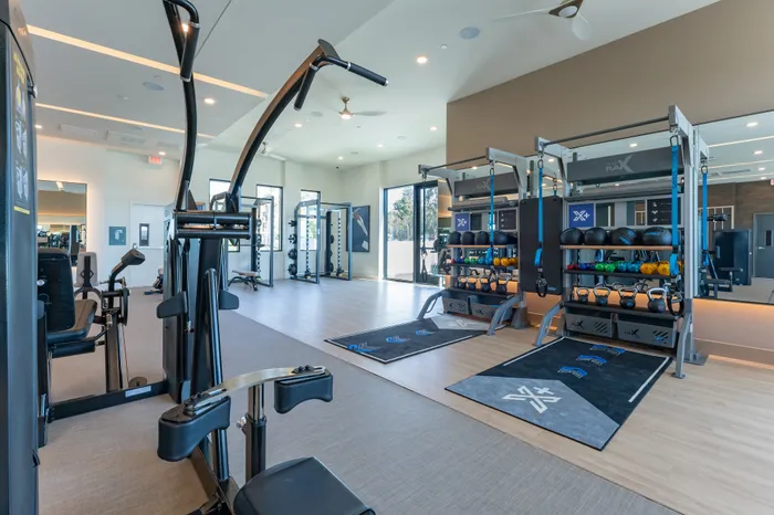 Modern fitness center with state-of-the-art equipment, open layout, and abundant natural light.