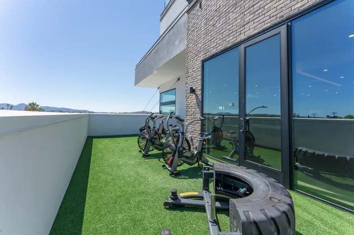 Modern rooftop terrace with fitness bikes and stunning mountain views, perfect for outdoor workouts and relaxation.