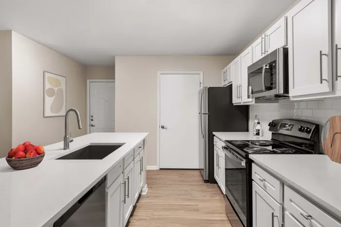Modern kitchen with sleek white cabinetry, stainless steel appliances, and a spacious island counter.