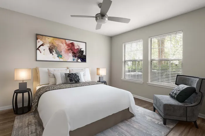Bright, modern bedroom with elegant decor, featuring a plush bed, stylish artwork, and ample natural light from large windows.
