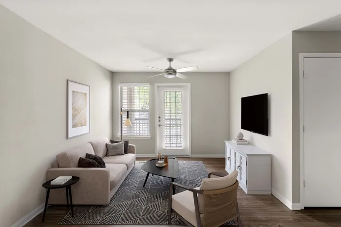 Bright and inviting living room with modern decor, featuring a cozy sofa, stylish armchair, and elegant TV setup.