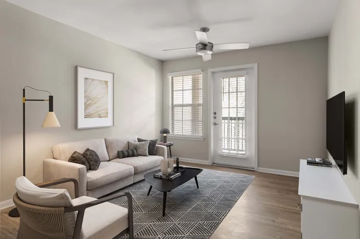 Modern living room with stylish beige sofa, elegant decor, and natural light streaming through large windows.