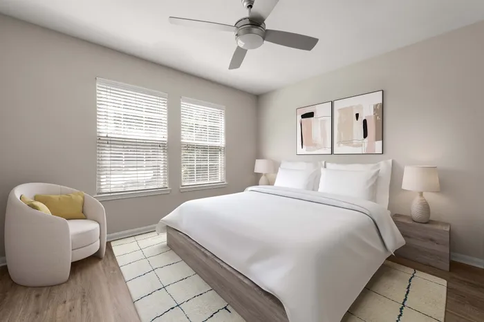 Elegant bedroom with natural light, featuring a plush bed, stylish armchair, and modern decor.