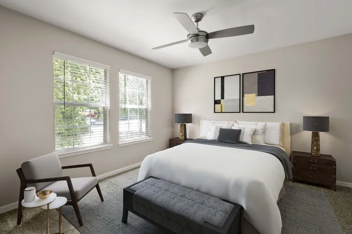 Bright and inviting bedroom with modern decor, featuring a plush bed, stylish armchair, and elegant artwork.