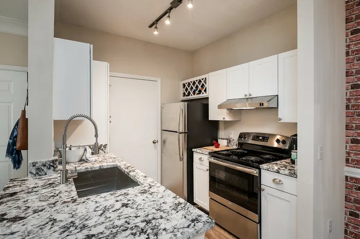 Elegant kitchen with modern stainless steel appliances, stylish granite countertops, and soft overhead lighting.