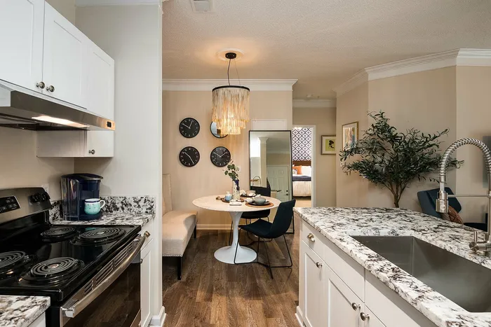 Elegant open-concept kitchen and dining area with sleek granite countertops and stylish pendant lighting, perfect for modern living.