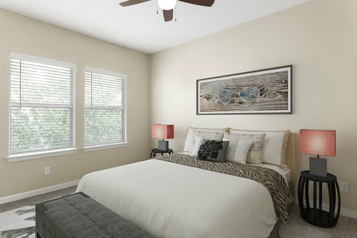 Serene bedroom with large windows, stylish decor, and cozy bedding under a modern ceiling fan.