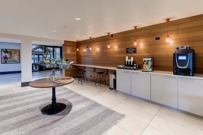 Inviting lounge area with a sleek coffee station, modern decor, and elegant lighting, perfect for relaxation or social gatherings.