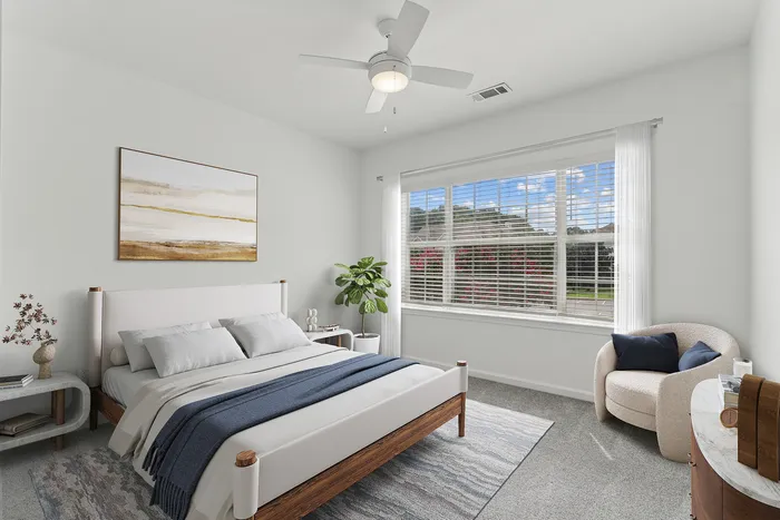 Bright and airy bedroom with modern decor, featuring a cozy bed, stylish armchair, and large window with lovely outdoor views.