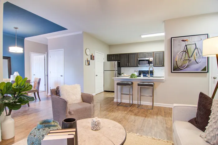 Inviting open-plan living area showcasing a modern kitchen with sleek cabinets, cozy seating, and stylish decor.