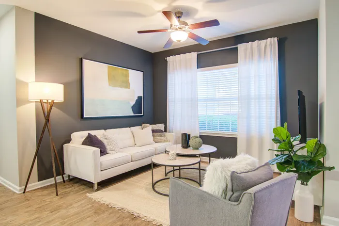 Inviting open-plan living area showcasing a modern kitchen with sleek cabinets, cozy seating, and stylish decor.