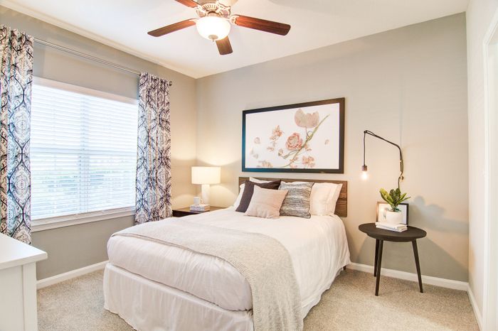 Inviting bedroom with elegant decor, featuring a comfortable bed, stylish artwork, and abundant natural light.