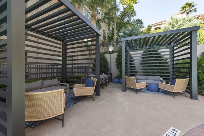 Chic outdoor lounge with modern pergolas, cozy seating, and lush greenery for a serene retreat.