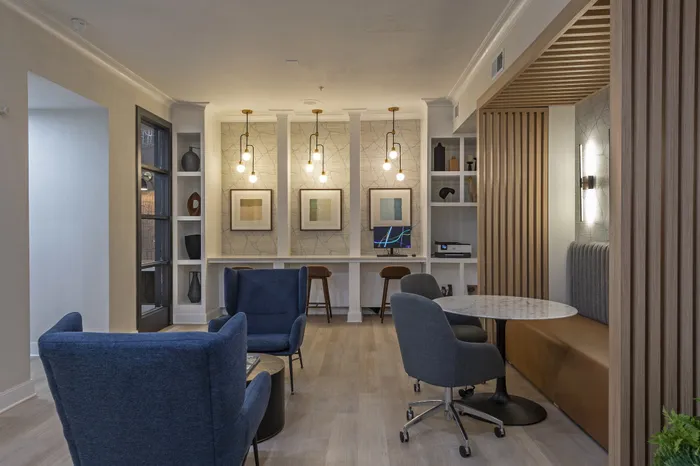 Sophisticated lounge area with modern chairs, elegant lighting, and stylish wood paneling offering a cozy ambiance.