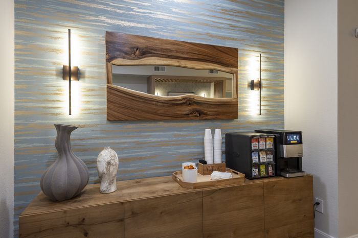 Chic apartment coffee nook featuring a wooden cabinet, stylish vases, and a modern coffee machine with a warm lighting ambiance.