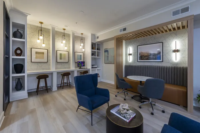 Modern lounge area with stylish seating, elegant lighting, and contemporary artwork, perfect for relaxation or collaborative work.