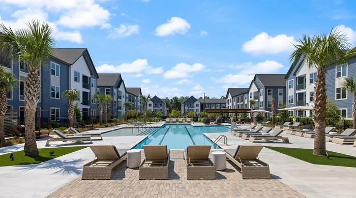 Pool courtyard with palm trees, chaise loungers and outdoor kitchen