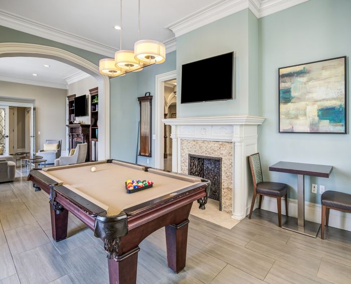 Luxurious entertainment room with elegant pool table, modern fireplace, and stylish seating area.