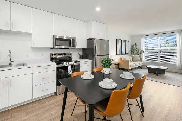 Modern open-concept kitchen and living room with sleek appliances, stylish dining area, and bright natural light.