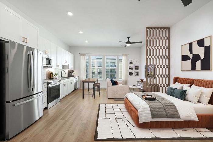 Modern open-concept studio apartment featuring a sleek kitchen, cozy living area, and stylish bedroom with elegant decor.