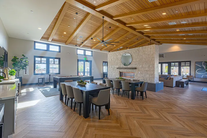 Spacious contemporary lounge with elegant wooden ceiling, chic lighting, and cozy fireplace, perfect for gatherings and relaxation.