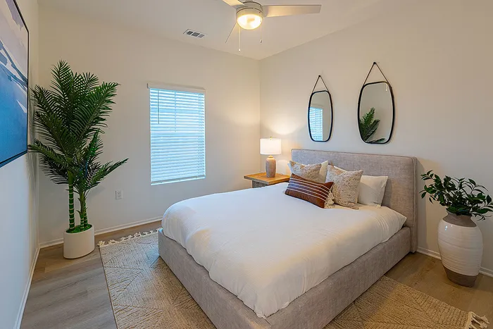 Inviting bedroom with a cozy bed, modern decor, and abundant natural light.