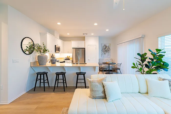 Bright and modern open-concept living space featuring a stylish kitchen with a breakfast bar, cozy seating area, and elegant dining nook, perfect for entertaining.