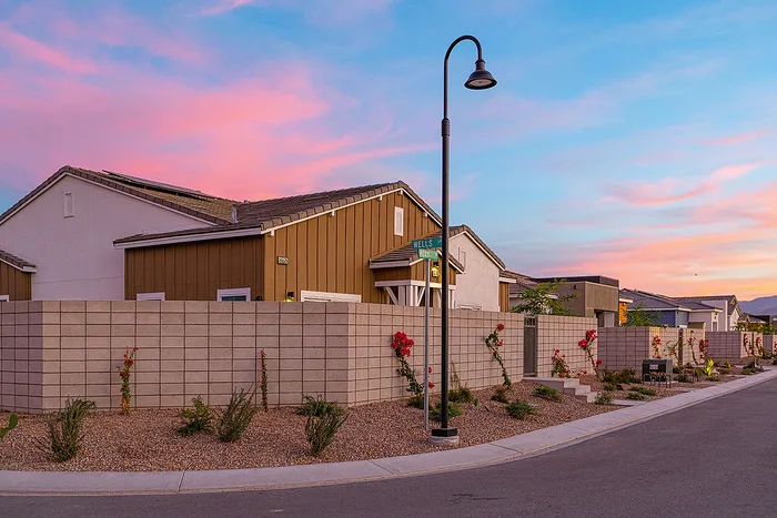 Charming suburban street view with modern homes at sunset, vibrant sky, and desert landscaping.