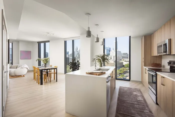 Bright and modern kitchen and dining area with floor-to-ceiling windows offering stunning city views.