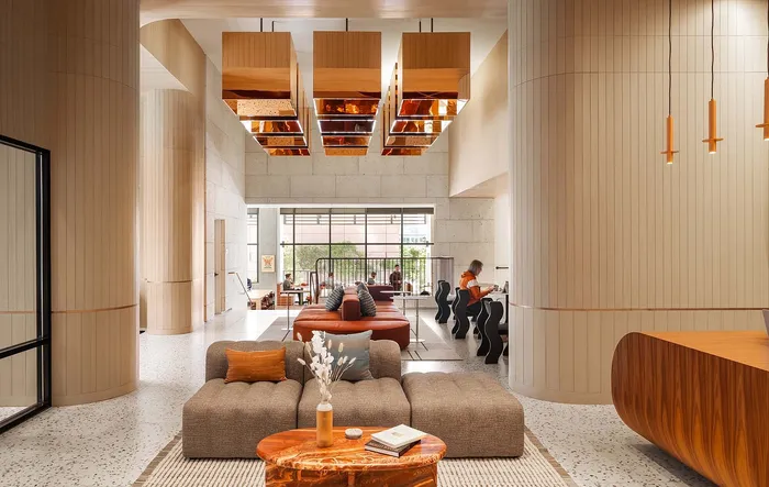 Modern and inviting interior space featuring chic seating, elegant wood paneling, and stylish pendant lighting.
