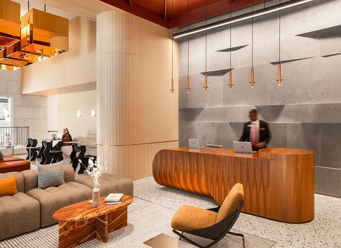 Sophisticated hotel lobby with modern design, elegant wood reception desk, stylish seating, and ambient lighting.