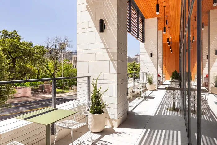 Chic outdoor patio with elegant seating and lush greenery overlooking scenic city views.