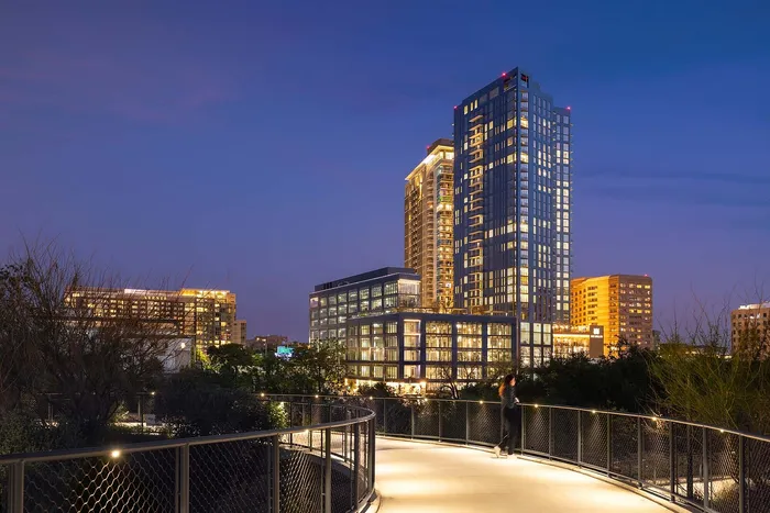 Illuminated skyscrapers create a stunning cityscape at dusk, offering a vibrant urban living experience with modern architecture and scenic views.