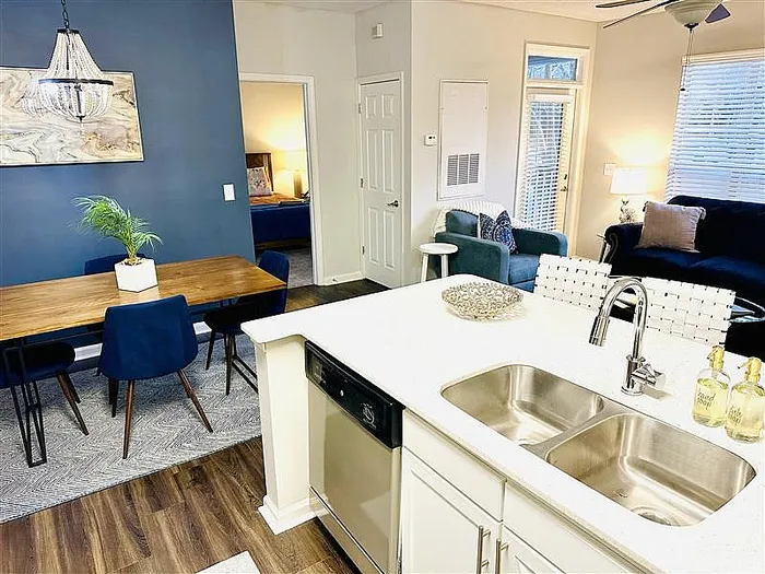 Chic open-concept apartment with modern kitchen, stylish dining area, and cozy living room, perfect for entertaining.