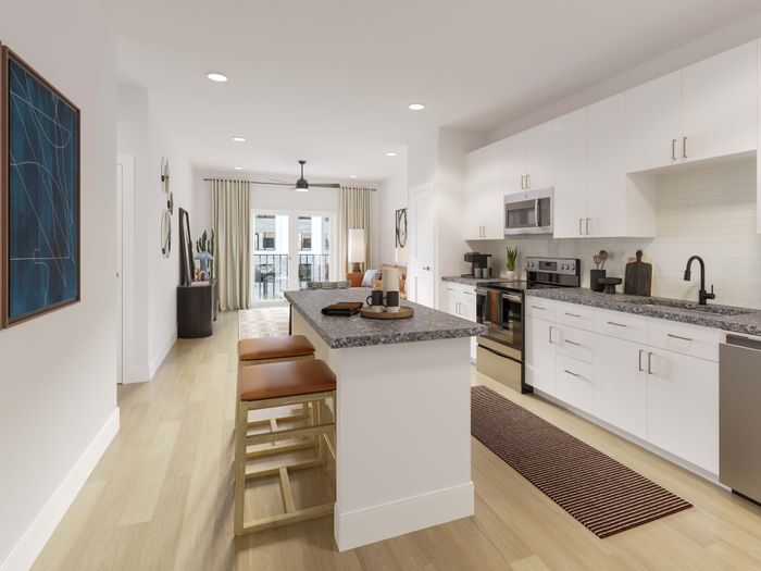 Modern kitchen with sleek cabinetry, island seating, and bright, airy dining area opening to a balcony.