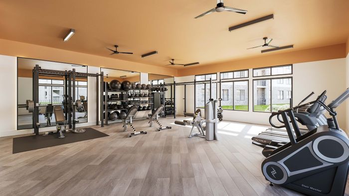 Modern fitness center with state-of-the-art equipment, spacious layout, and large windows offering natural light.