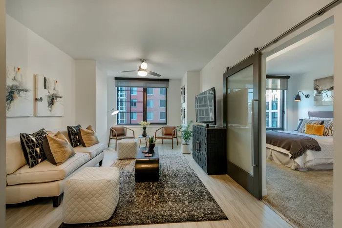 Elegant living area with stylish decor, large windows, and a cozy adjoining bedroom with modern furnishings.