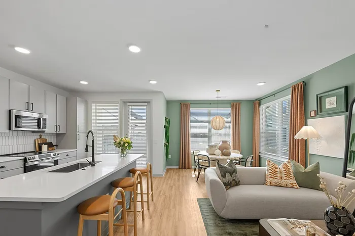 Modern open-concept living area with sleek kitchen, stylish seating, and elegant dining space.